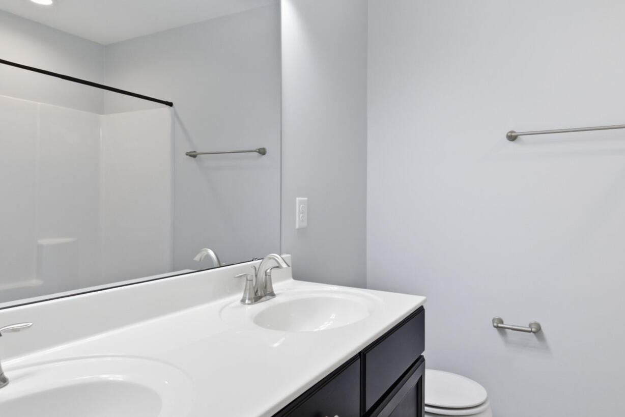 Primary bathroom with double vanity and glass shower in the Garner, NC townhouse rental