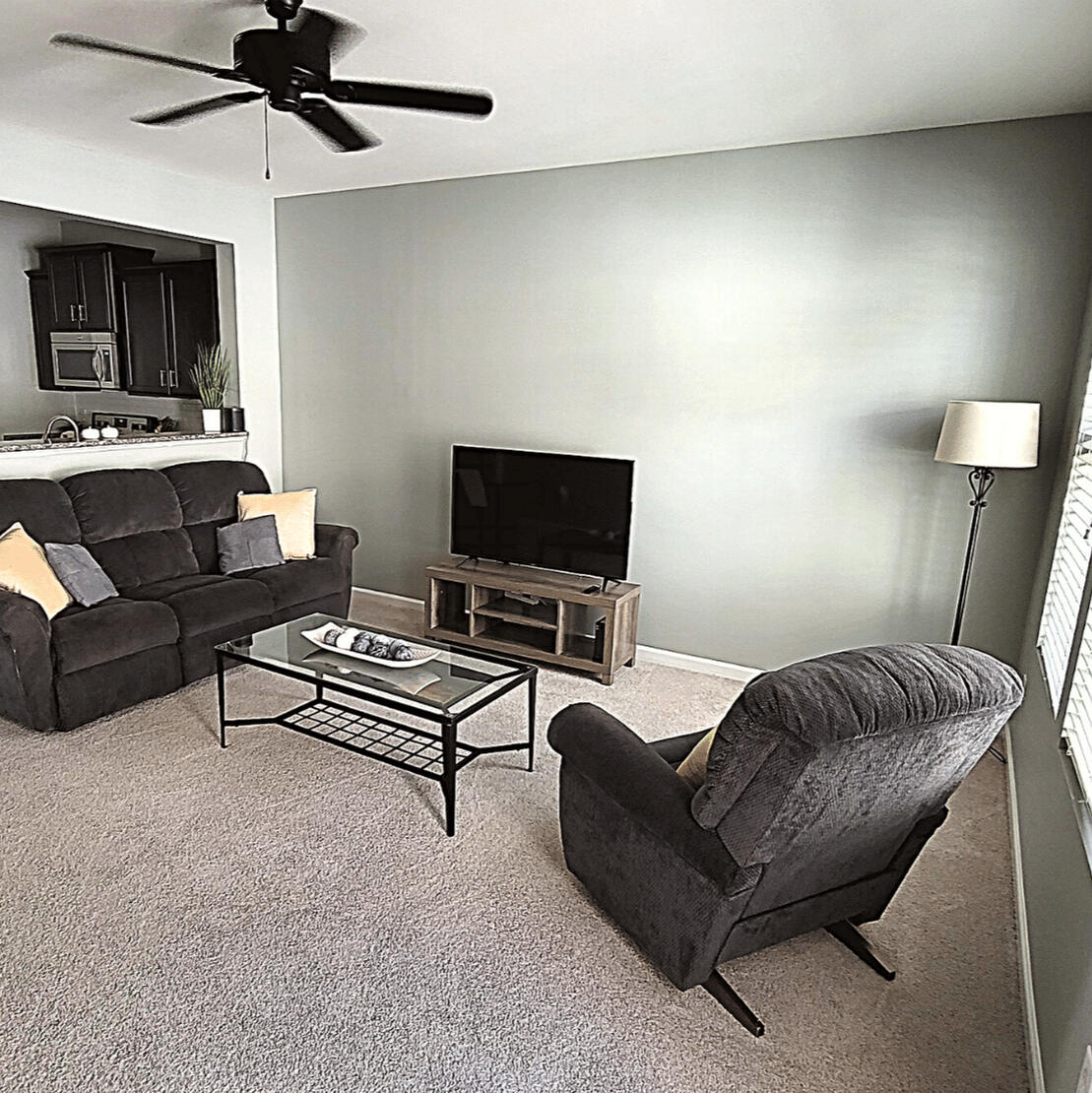 Living room with sectional sofa and TV in the furnished Wake Forest rental